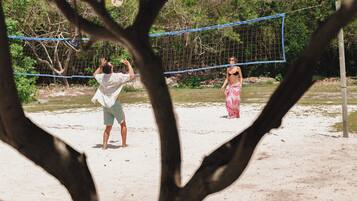 Una red de voleibol con dos jugadores al fondo.
