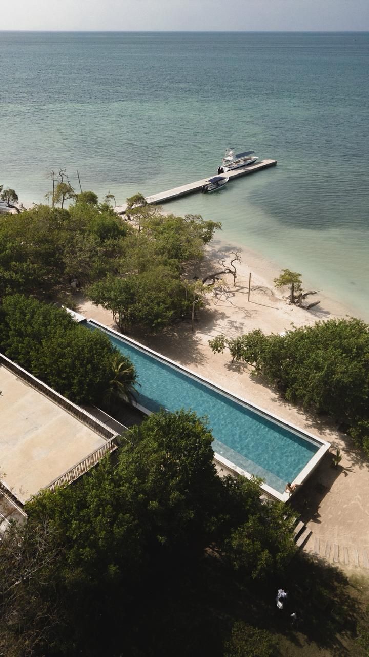 Una piscina junto a una playa con un muelle.