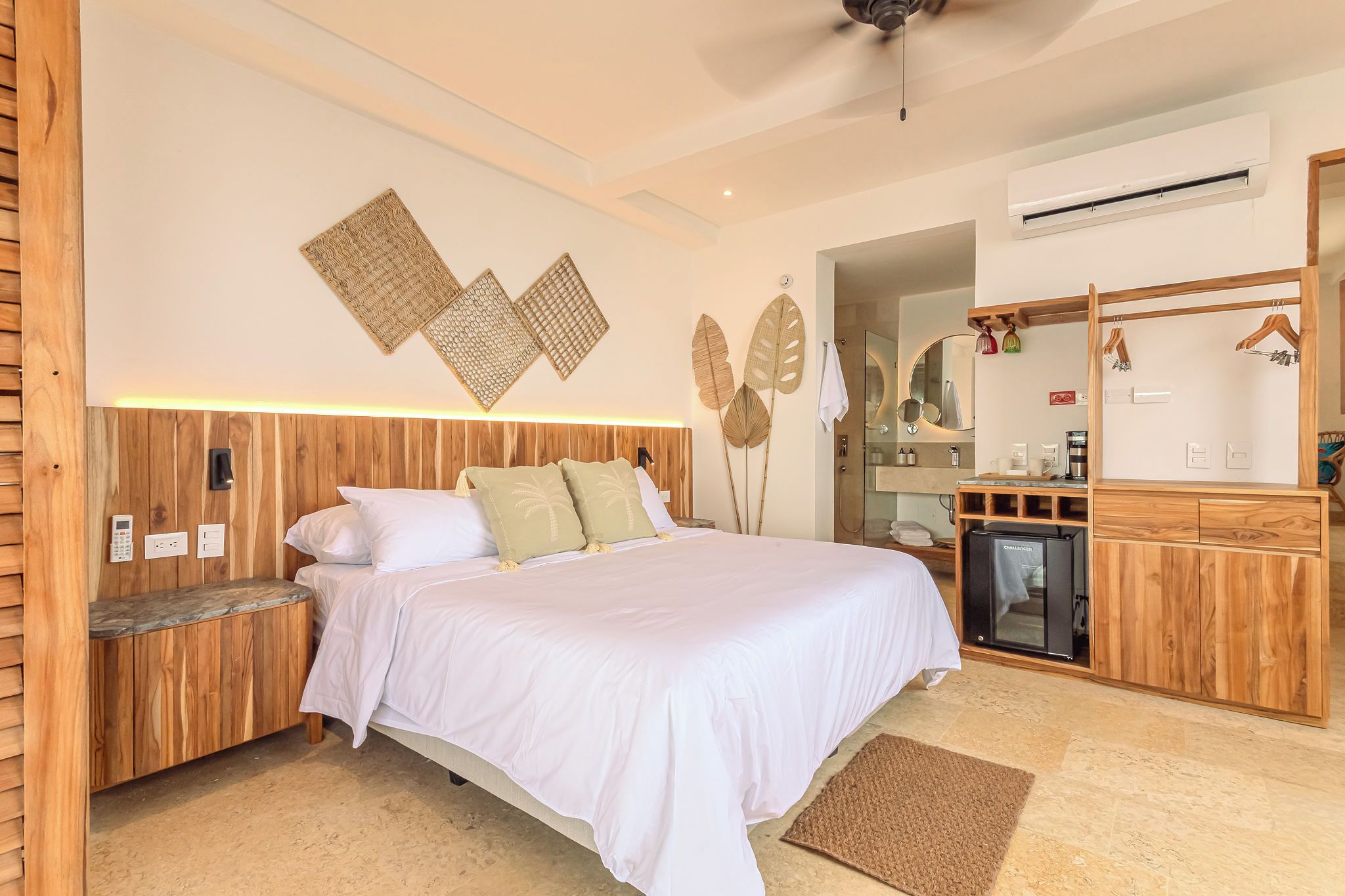 A bedroom with a bed, bedside tables, a wardrobe, a mirror, and a shower area.