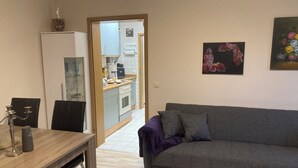 Un espacio habitable compacto con comedor, kitchenette y sofá.