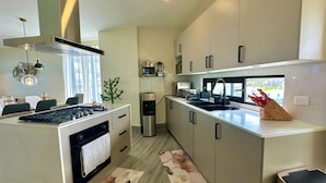 Una cocina moderna con una isla central, electrodomésticos de acero inoxidable y un horno empotrado.