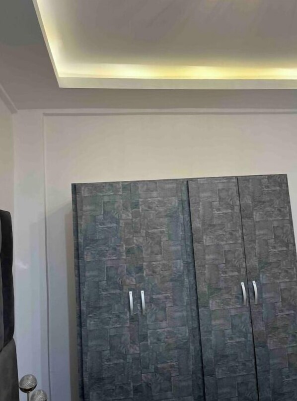 Habitación con armario de diseño que imita piedra, con dos puertas y tiradores plateados.