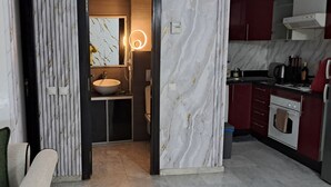 Una cocina moderna con protector mural de mármol, horno empotrado y fregadero.