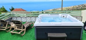 Ein Whirlpool mit Bedienfeld, zwei Liegestühle und Meerblick.
