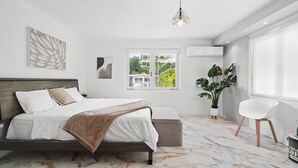 A modern bedroom with a bed, a window, a potted plant, and a chair. - Nice Pool w Breathtaking Mountain Views BBQ (Carolina)