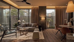 A modern living room with a sofa, coffee table, and dining area.