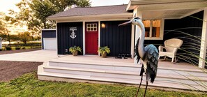 A building with a red door, a number '16815' above it, and a large bird statue on the porch. - Charming 2-bedroom cottage with WiFi, AC in Spring Lake (Spring Lake)