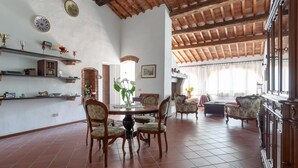 A spacious dining area with a high wooden ceiling, tiled floor, and traditional furniture. - Nice Apartment With Swimming Pool (Peccioli)