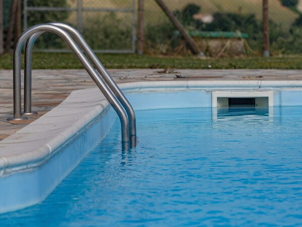 A swimming pool with a metal ladder and a small rectangular opening at the bottom. - Farmhouse in Marche With Pool & Verdicchio Wines (Montecarotto)
