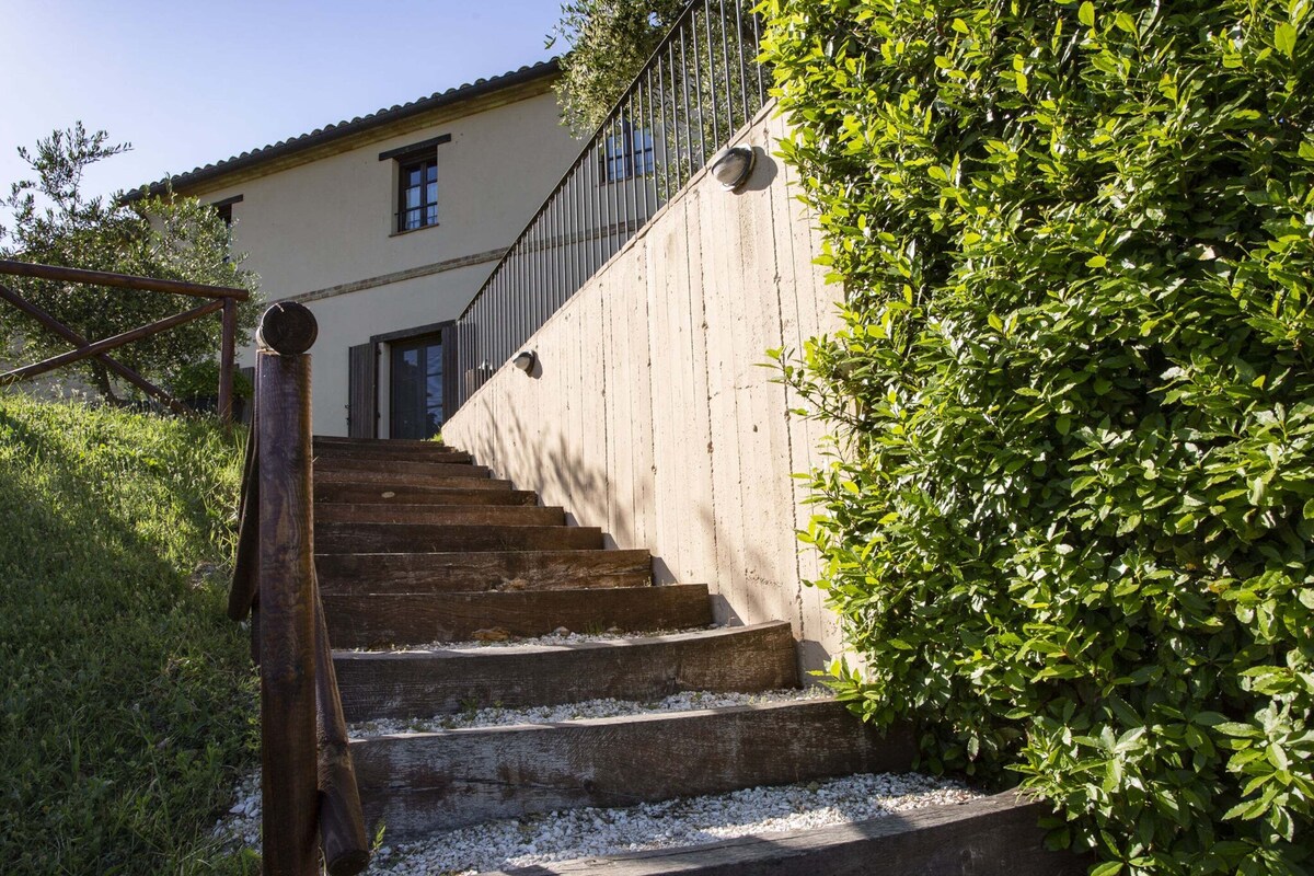 A set of outdoor stone steps leading up to a building with a metal railing.