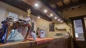 Una barra de madera con una escultura decorativa de cabeza de caballo, una botella DGM y un panel de menú en un restaurante.