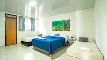A hotel room with two beds, a large window with curtains, a painting on the wall, and a tiled floor.