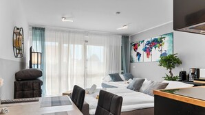 A modern hotel room with a large bed, a desk, and a dining area. - Design luxury, fully equipped, 30min Leipzig Hbf 8 (Schkeuditz)