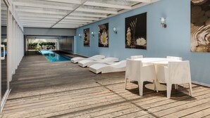 A covered outdoor area with a pool, white lounge chairs, and a table with chairs. - Modern 2BR Duplex, with balcony. (Ciudad de México)