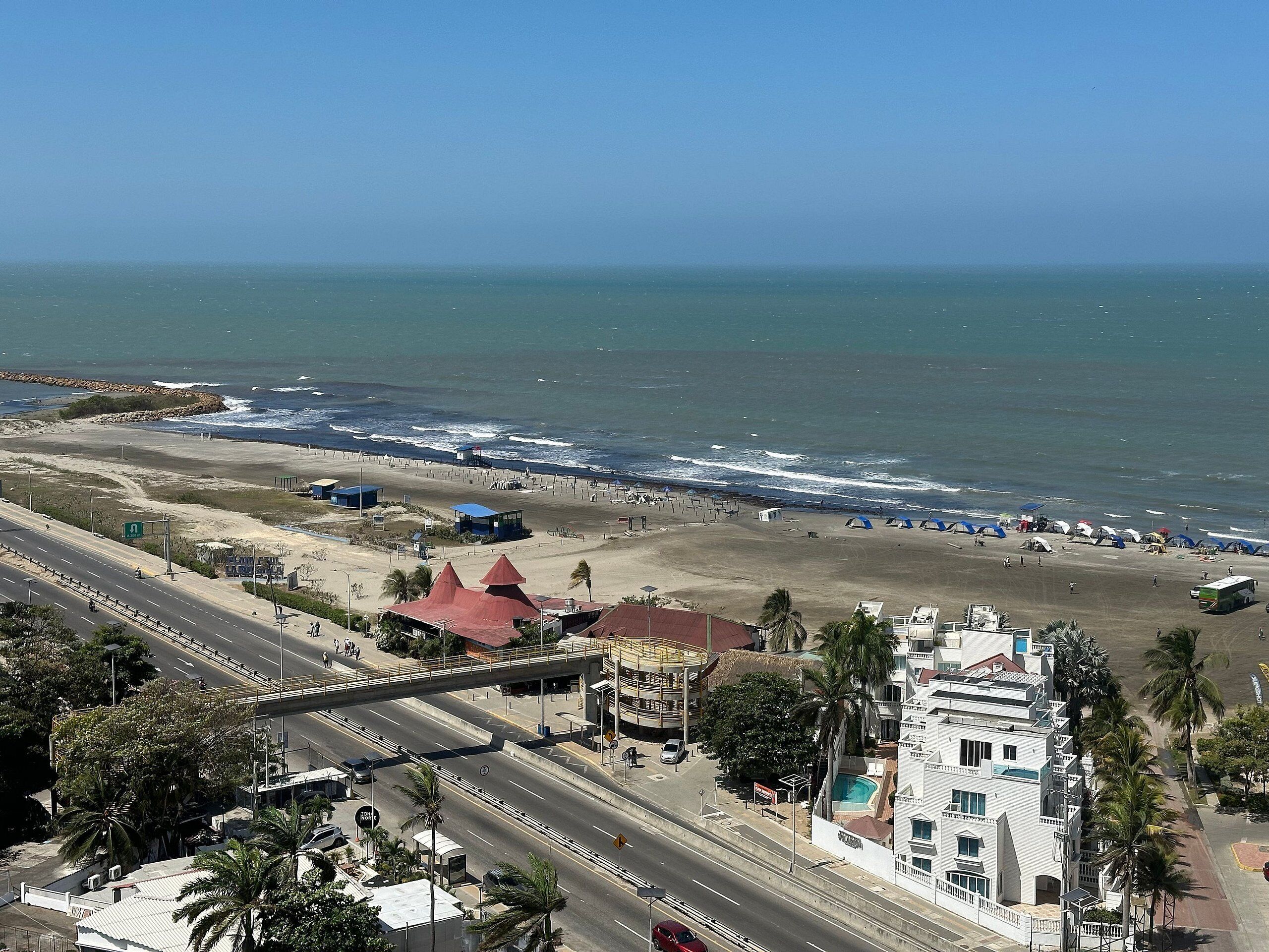 Una carretera costera con playa y un hotel.