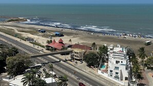 A coastal road with a beach and a hotel. - Sunno Beach Condominium - Playa Azul (Cartagena)