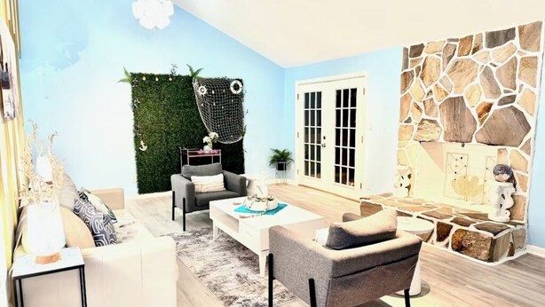 Una sala de estar moderna con un sofá, sillones, una mesa de centro y una pared decorativa de piedra.