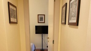 A hallway with wooden flooring, a bed in the background, and framed pictures on the walls. - Suite51 - Cozy apartment in Porta Romana near the center (Milano)