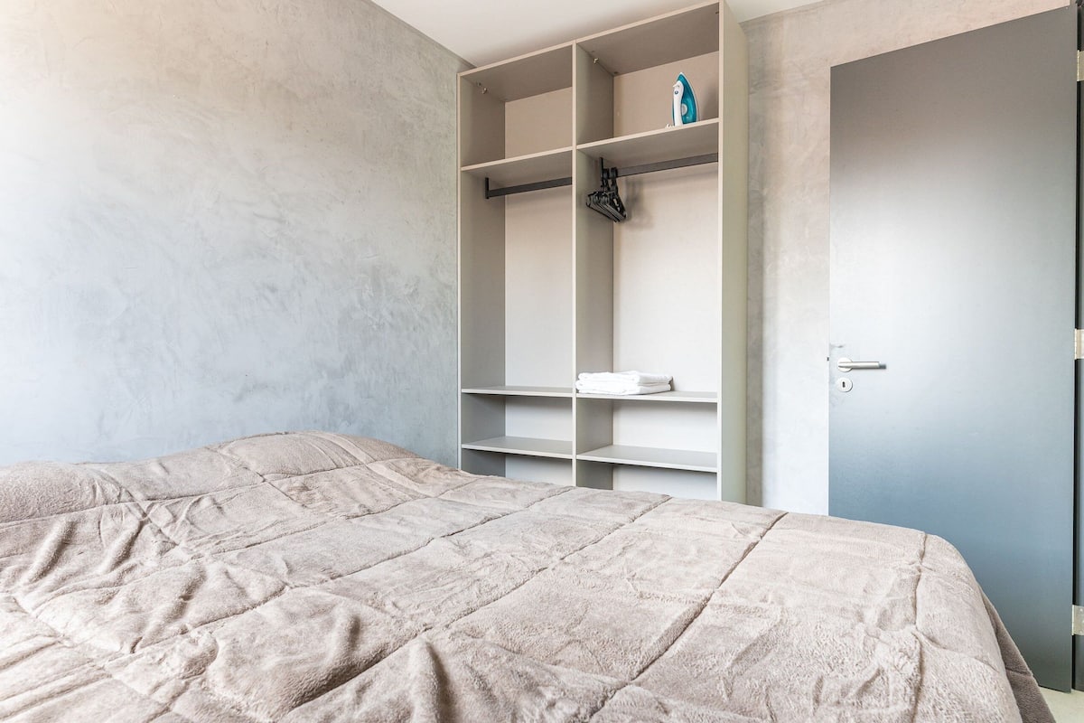 Une chambre à coucher avec un lit, une armoire et une porte.