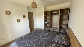 Quarto com cama, guarda-roupa e luminária pendente.