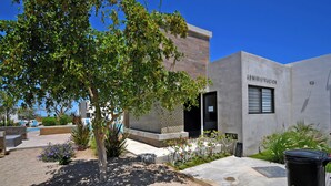 A modern building with a sign reading "ADMINISTRACION" and a well-maintained outdoor area with plants and seating. - Family Homes with Pool and Playground (La Paz)