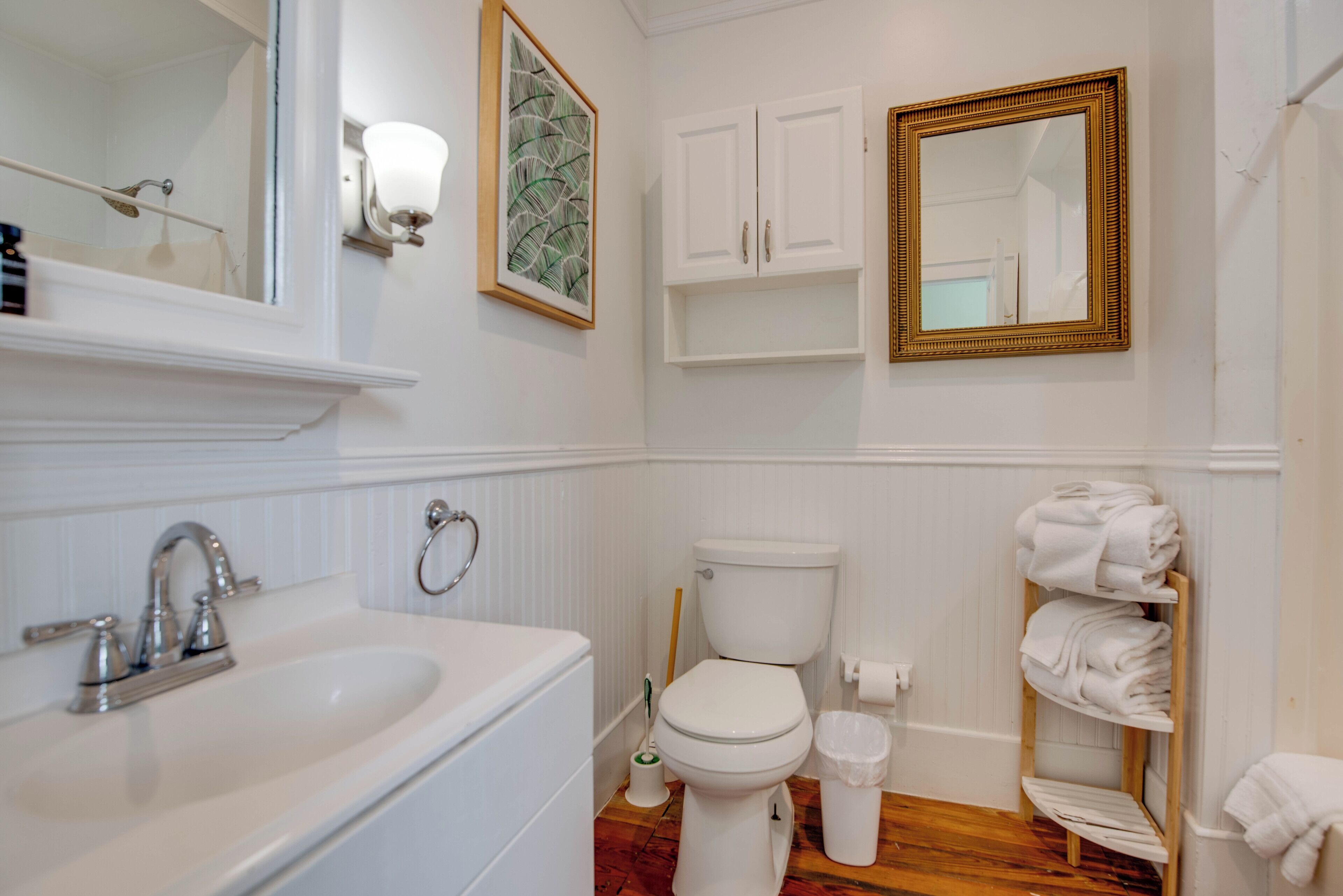 A bathroom with a white sink, toilet, and a towel rack.