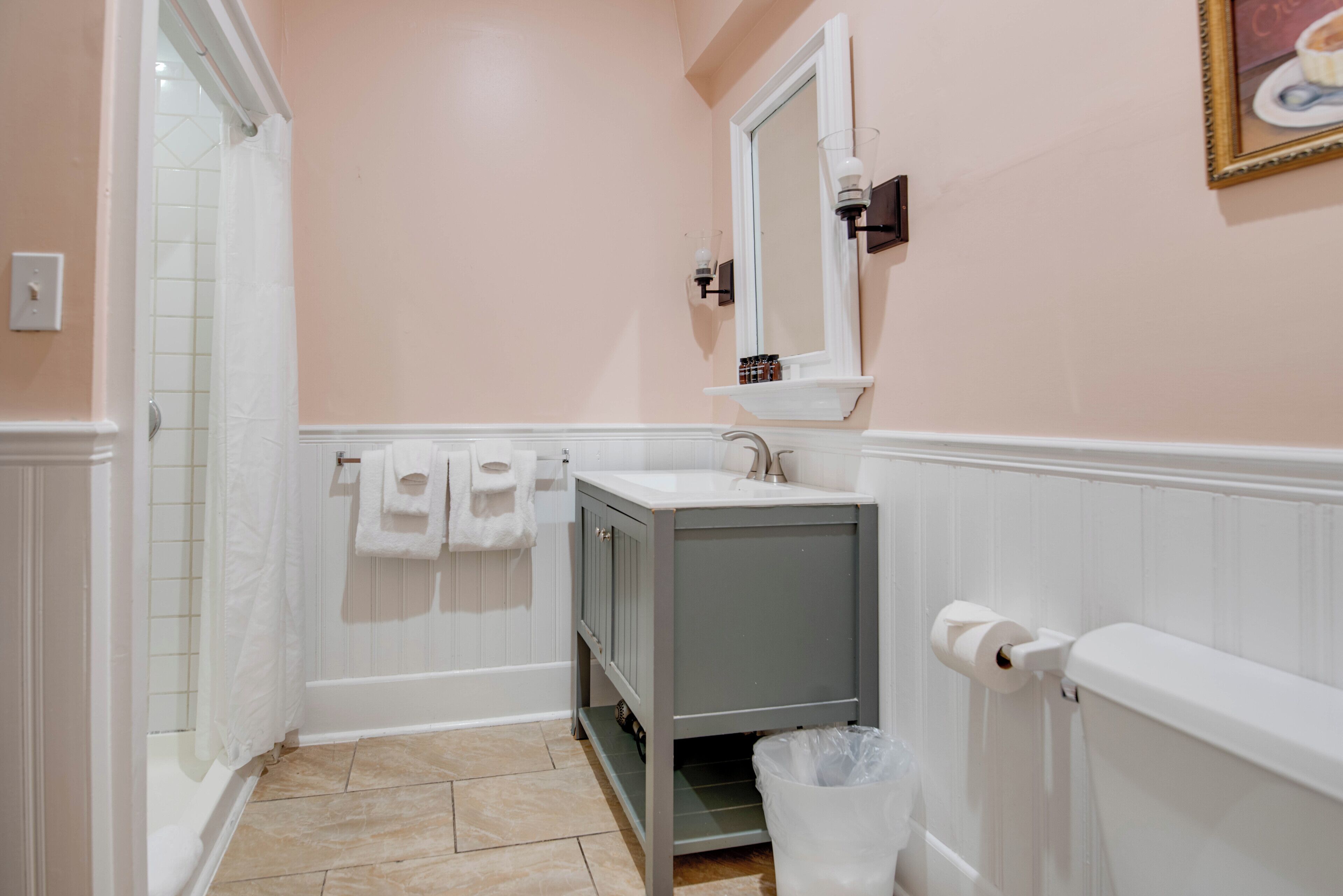 A bathroom with a white sink, a mirror, and a shower.