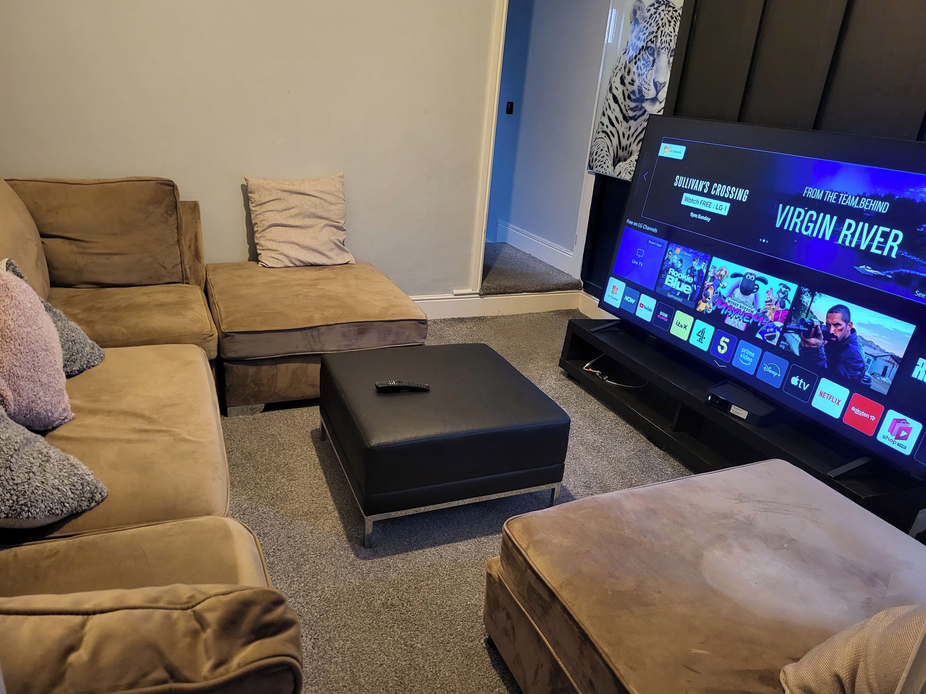 A living room with a large flat-screen TV displaying a streaming service interface.