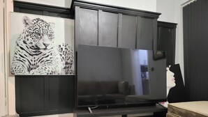 A living room with a large flat-screen TV, a sofa, and a coffee table. - Apartment - Sleeps 5 - Great Location - Parking (Stoke-on-Trent)