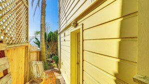 A narrow pathway leading to a yellow door, flanked by wooden fences and a palm tree. - Urban San Francisco Retreat: Stunning City Views! (San Francisco)