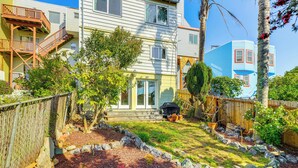 A two-story house with a front porch, a backyard with a wooden fence, and a small garden area. - Urban San Francisco Retreat: Stunning City Views! (San Francisco)
