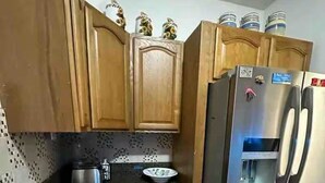 Una cocina con armarios de madera, un refrigerador de acero inoxidable y un microondas.