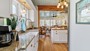 A spacious kitchen with wooden flooring, white cabinetry, and a central island. - Your Ultimate Coastal Retreat! 5 bedroom, 4 bathroom home in Murrells Inlet, SC! (Murrells Inlet)