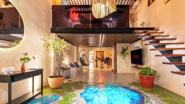 Een modern interieur met een uniek vloerontwerp, een trap en een televisie.