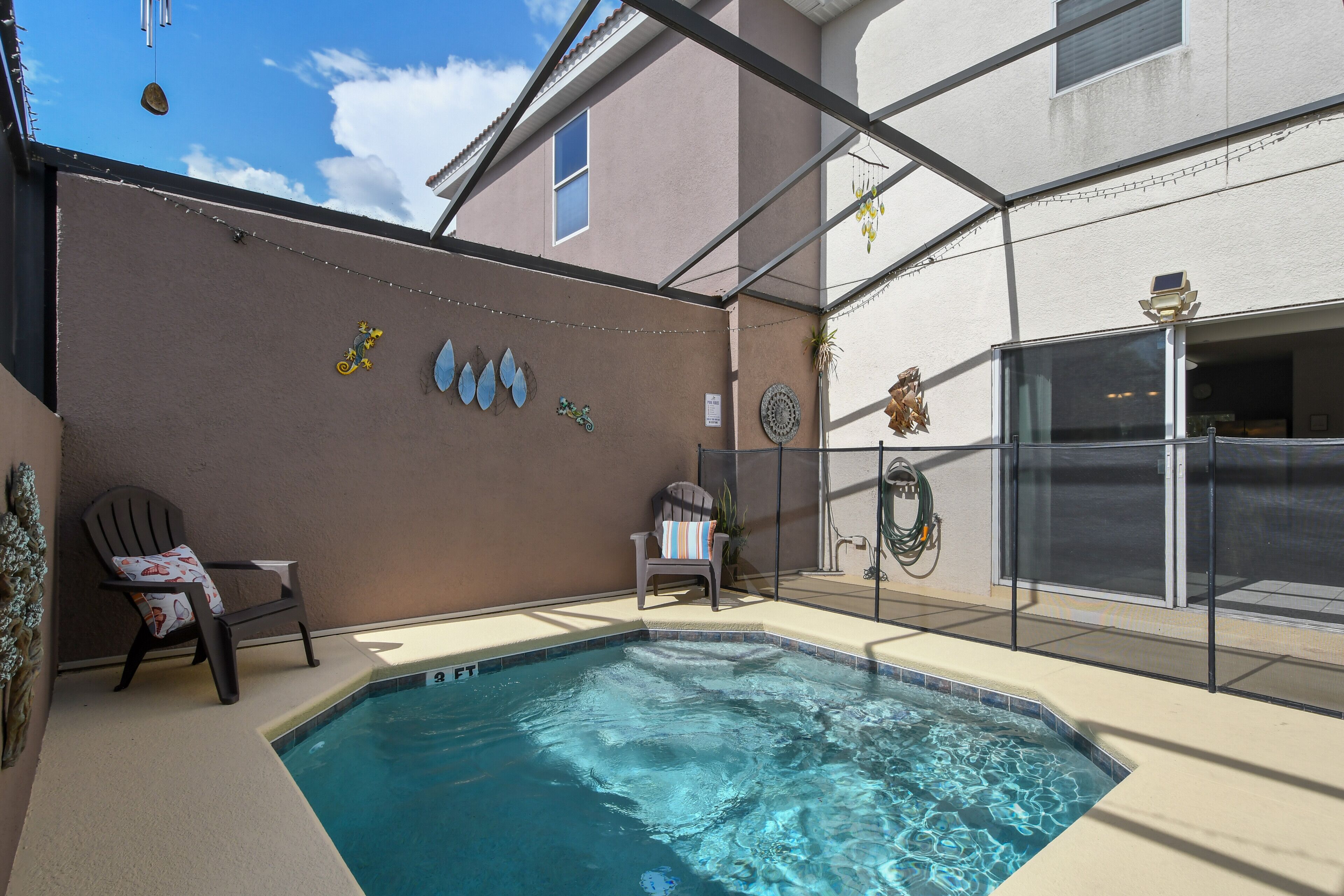 Une piscine avec des chaises et des éléments de décoration, par une journée ensoleillée.