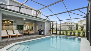 A swimming pool with lounge chairs and a covered patio area.
