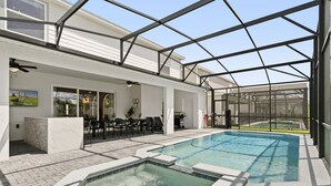 Una piscina coberta a l'aire lliure amb una banyera d'hidromassatge, envoltada per una zona de terrassa amb mobiliari exterior i vista a un camp de golf.