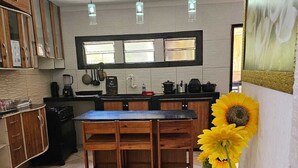 Une cuisine avec des meubles en bois, un îlot central et une grande décoration représentant un tournesol.