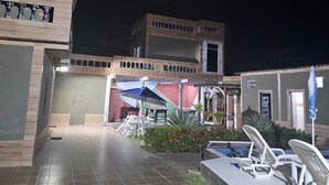 Un edificio de dos pisos con piscina y zona de estar al aire libre.