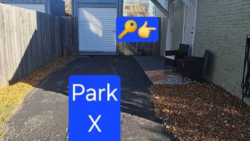 A parking area with a blue sign indicating a parking spot marked 'Park X'.
