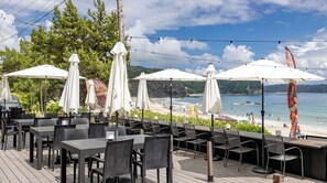 Relax in a tranquil outdoor space surrounded by lush greenery and a wooden deck, with access to the beach.