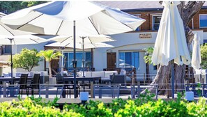 Relax in the hotel's spacious patio, surrounded by lush greenery and offering a clear view of the building's facade.