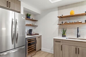 A modern kitchen with stainless steel appliances, wooden cabinets, and built-in wine racks. - Near Westin | Top Floor | Hot Tub | Workspace (Scottsdale)