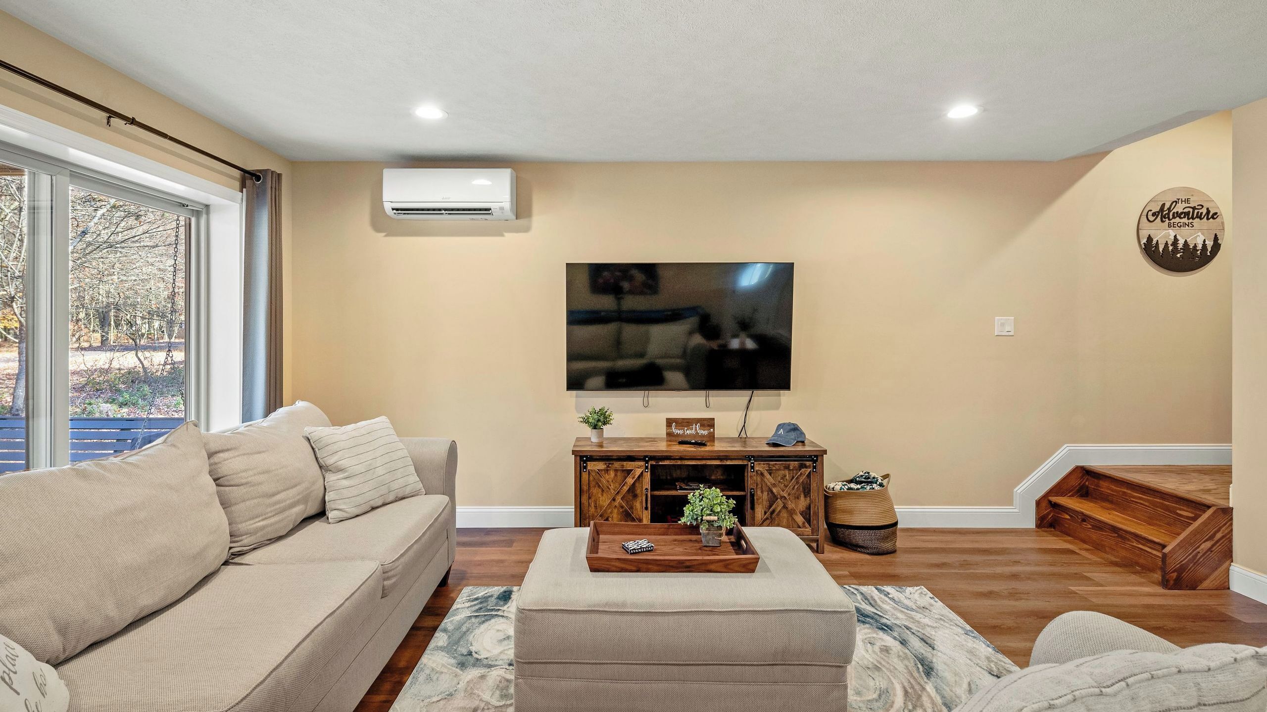 A living room with a sofa, a coffee table, a TV, and a fireplace.