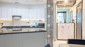 A modern kitchen with white cabinets, a black countertop, and a built-in microwave.