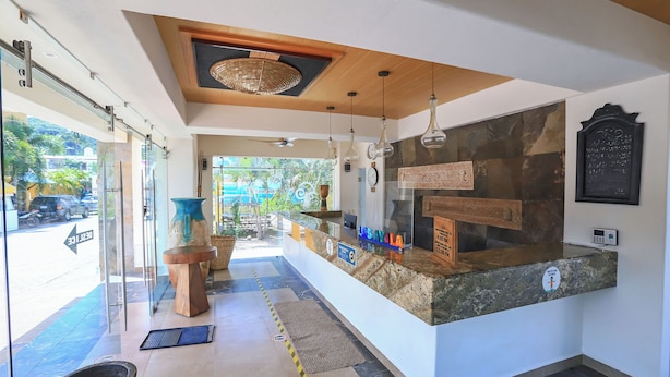 A reception area with a counter, a wooden ceiling, hanging lights, and a view of the outdoors. - Hotel & Villas Quinta Minas (Los Ayala)