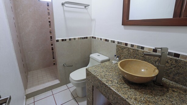 Un baño con inodoro, lavamanos y ducha.