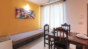 A dining area with a bench, wooden table, chairs, and a ceiling fan. - Hotel & Villas Quinta Minas (Los Ayala)