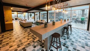 Ett modernt kök med en central köksö, barstolar och utsikt över gatan genom stora fönster.