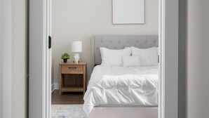 A bedroom with a bed, a nightstand, a lamp, and a framed picture on the wall. - Downtown Columbus~Stunning Upscale 1 bd Suite (Columbus)
